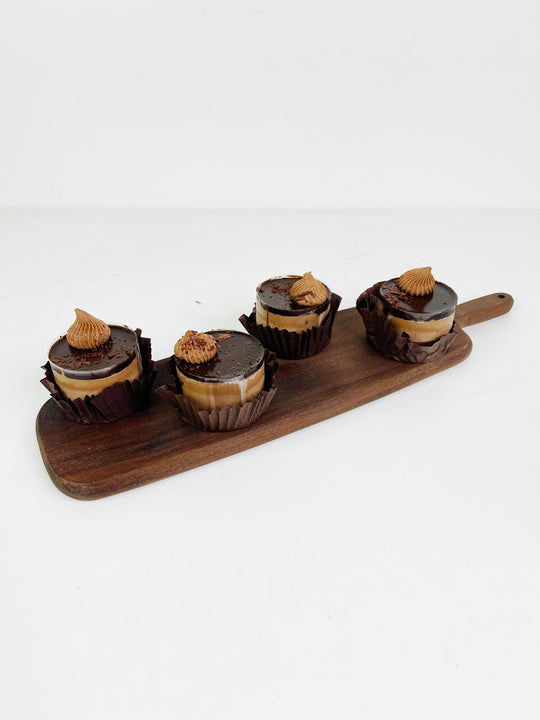
                  
                    Four chocolate desserts with peanut butter filling on a wooden board against a white background
                  
                