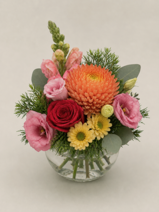 
                  
                    Colorful flower arrangement in a clear vase on a light background
                  
                
