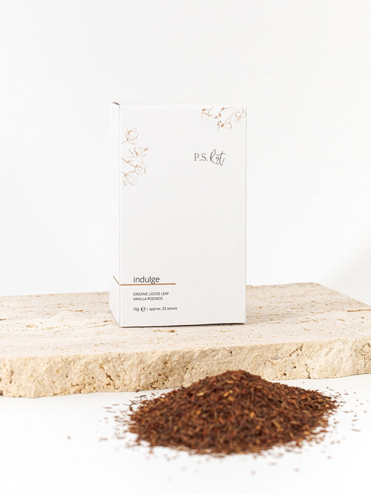 
                  
                    Box of 'indulge' organic coffee on a light wooden surface with ground coffee in front
                  
                