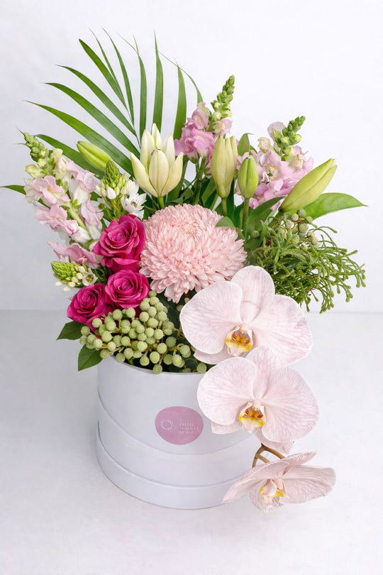 
                  
                    Floral arrangement with pink and white flowers in a box on a light background
                  
                
