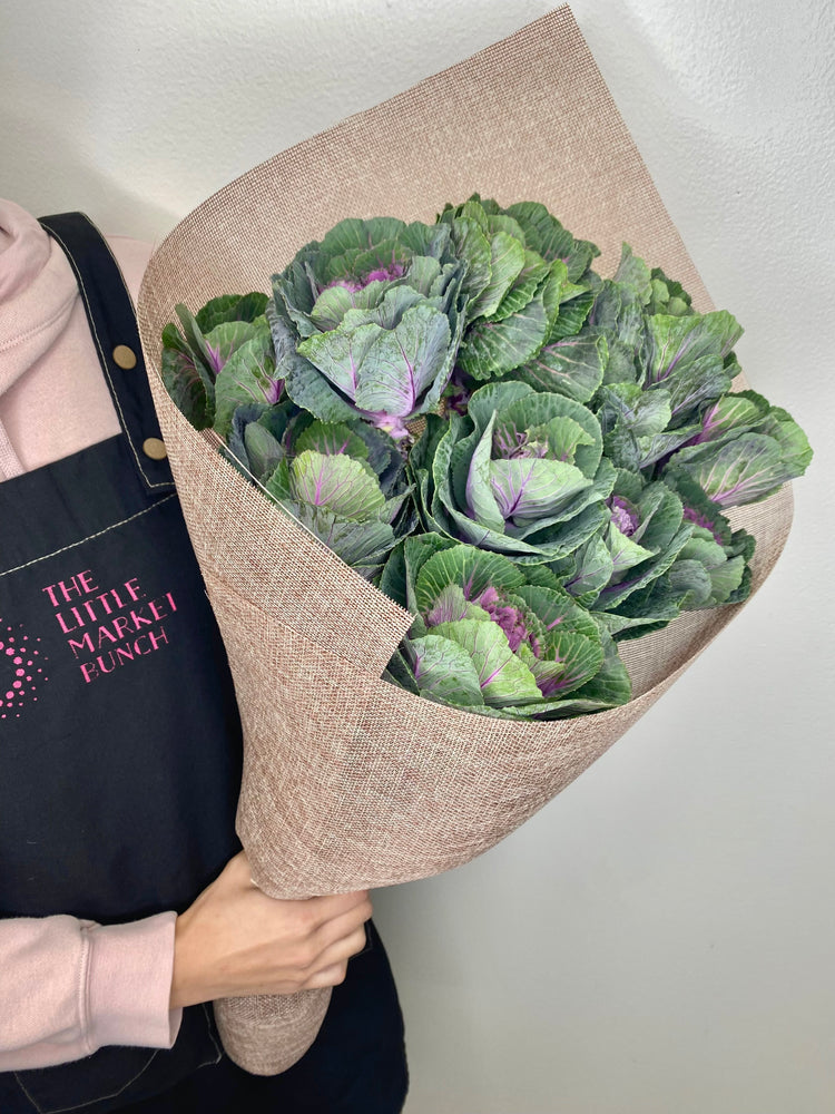 This image features a bouquet of ornamental kale, beautifully arranged with lush, textured leaves in shades of green and hints of purple. Wrapped in natural, brown burlap-style paper, the bouquet showcases a unique and earthy aesthetic.
shot by The Little Market Bunch, Melbourne.