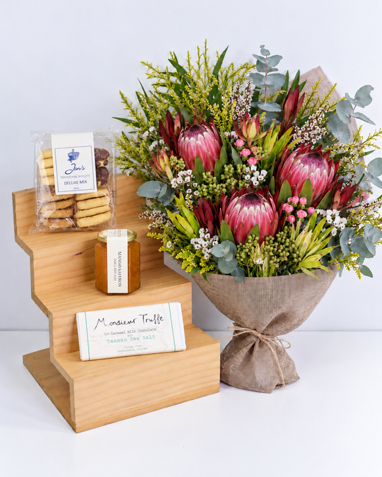 
                  
                    Bouquet of flowers, cookies, jam and a chocolate  on a wooden stand with a white background
                  
                