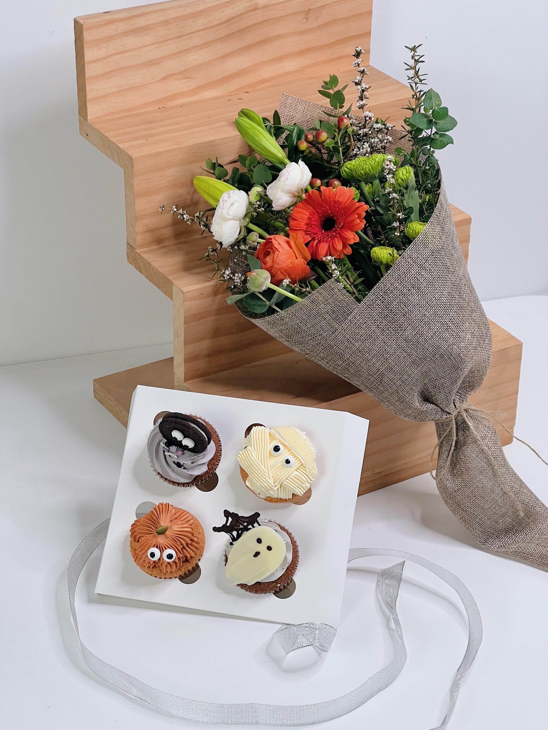 A packaged premium cupcake from Bito Beans with a flower bouquet from The Little Market Bunch, both presented on a white surface.