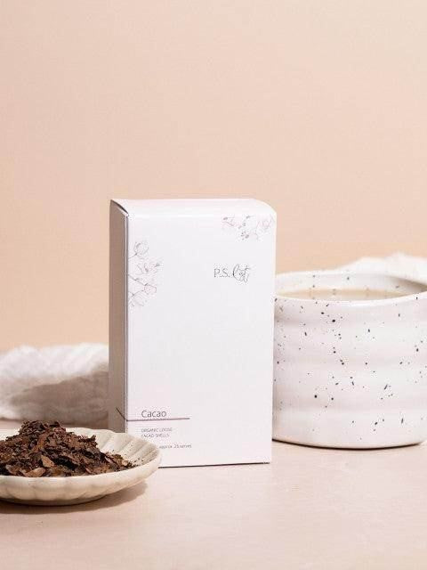 
                  
                    Cacao powder in a small dish with a box labeled 'Cacao' on a beige background
                  
                