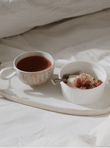 Cup of tea and dessert on a tray with white background